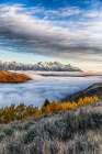 Layer of fog in the valley below the peaks of Grand Teton National Park. Art Print